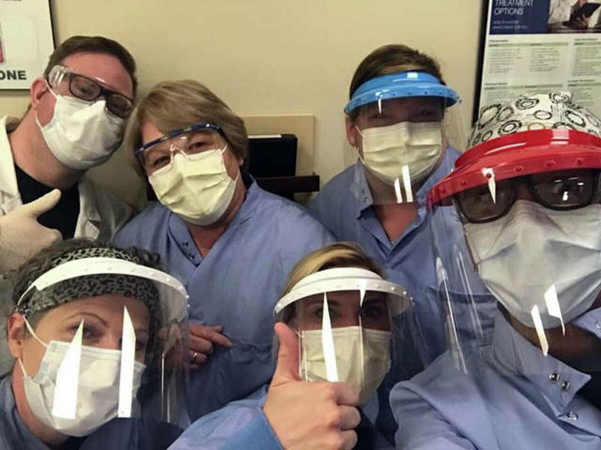 Shawna McMichael, front row center, and other members of her team from the home dialysis program at Washington University pose while wearing their personal protective equipment.