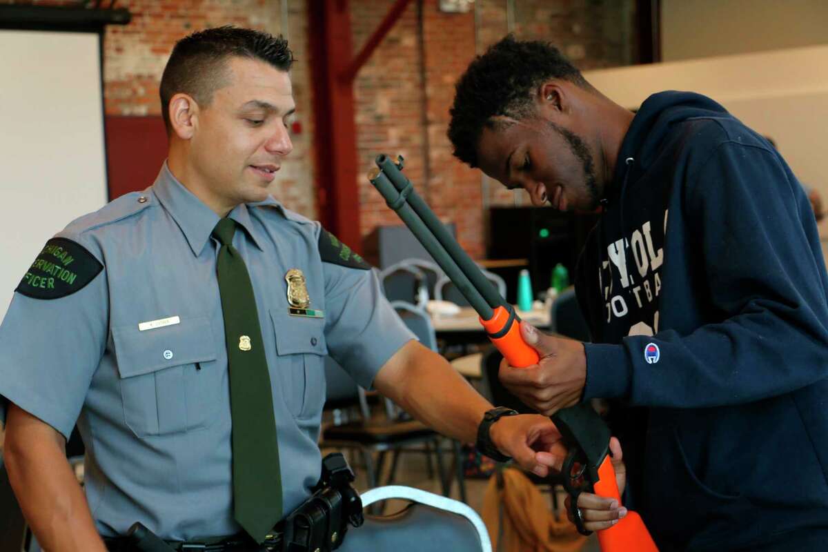 Michigan DNR Conservation Officer Keven Luther works with a young man during an August 2019 hunter education safety course. (Courtesy Photo)