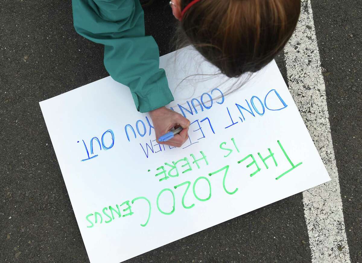 Karolina Ksiazek, Complete Count Program Manager, finishes a sign for the Party-On-Wheels to publicize the 2020 Census in the parking lot of the Second Star of Jacob Church in New Haven where the caravan began on May 8, 2020.