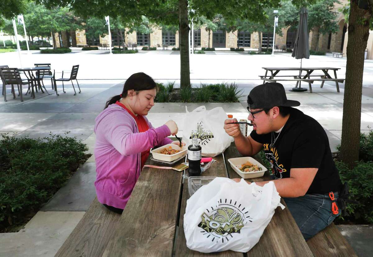 Ivan Naranjo, right, and Gisel Covarrubias, both students living in Esperanza Hall at Texas A&M University San Antonio, eat lunch just outside the cafeteria, usually crowded with students. The two chose to stay in the dorm instead of going home to Robstown.