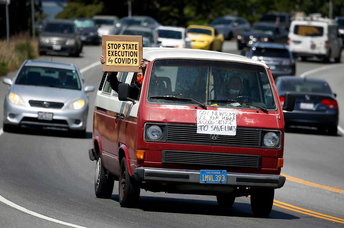 A long caravan of cars drives toward the west gate of San Quentin State Prison to demand more protection against the COVID-19 coronavirus for prisoners in Larkspur, Calif. on Saturday, May 9, 2020.