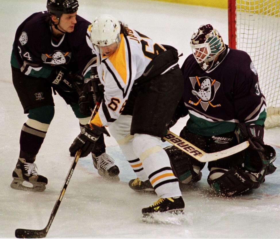 Pittsburgh Penguins Jaromir Jagr, center, tries to get a backhand shot off between Rusian Salei, left, and goalie Guy Hebert of the Mighty Ducks of Anaheim during first period NHL action Tuesday Dec. 1, 1998 in Pittsburgh.