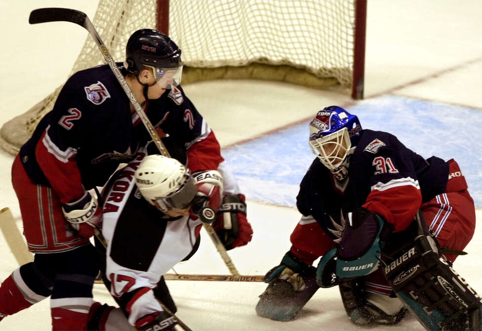 New York Rangers goaltender Guy Hebert, right makes a sava as teammate Brian Leetch (2) checks New Jersey Devils' Petr Sykora from behind during the second period Saturday, March 31, 2001, in East Rutherford, N.J. Hebert stopped 38 shots and the New York Rangers ended a 23-game winless streak that spanned four years against New Jersey, beating the Devils 4-3 Saturday.