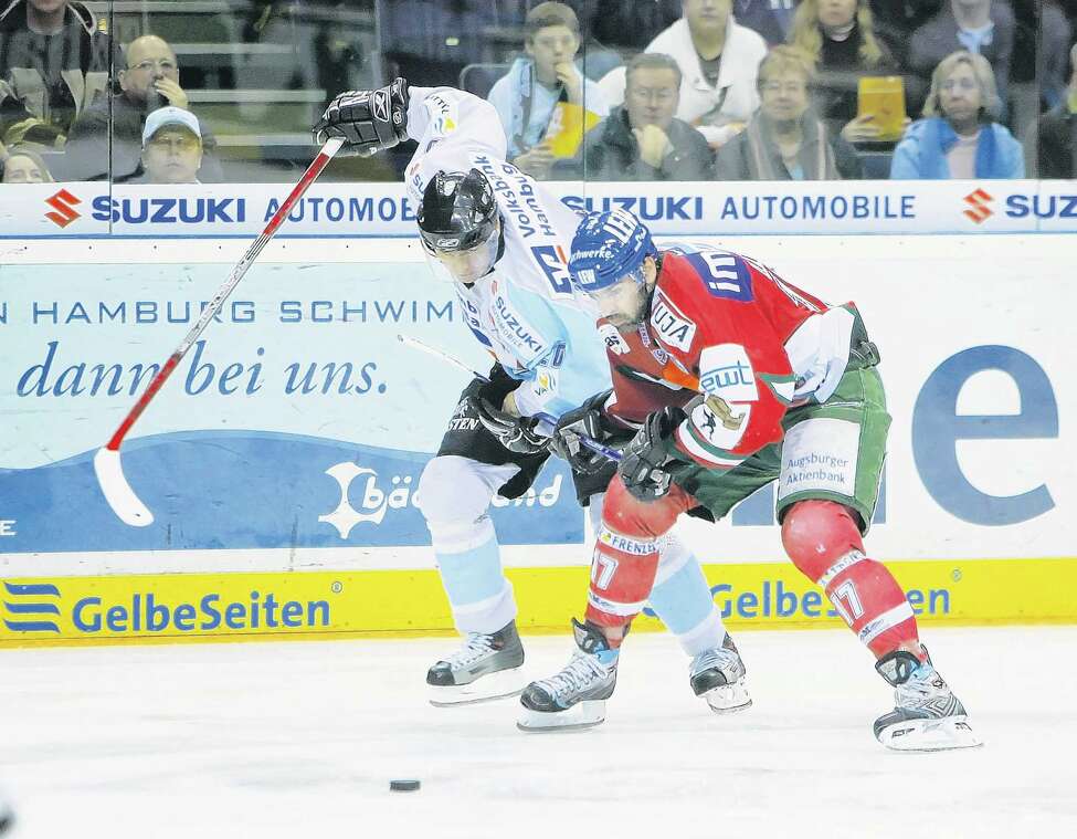 HAMBURG, GERMANY - JANUARY 21: Jacek Plachta of Hamburg challenges Craig Darby of Ausburg during the DEL Bundesliga game between Hamburg Freezers and Augsburger Panther at the Color Line Arena on January 21, 2007 in Hamburg, Germany.