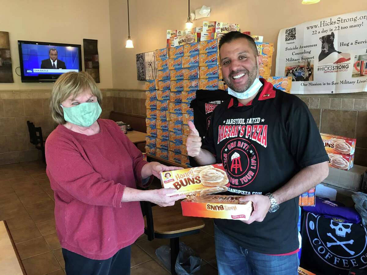 Regina Brown of Latham donates items to and Frank Scavio, Paesan's Paesan's Pizza owner, for shipment in care packages to soldiers on duty in Afghanistan. (Provided)