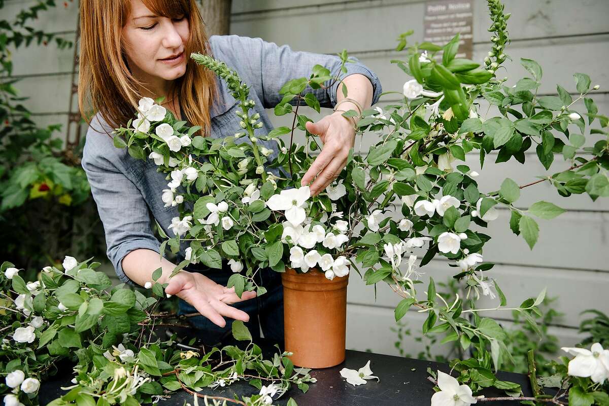 STEP 3: Rebekah Northway arranges flower cuttings in a terra-cotta pot at her flower shop The Petaler, in San Francisco, Calif, on Friday, May 8, 2020.