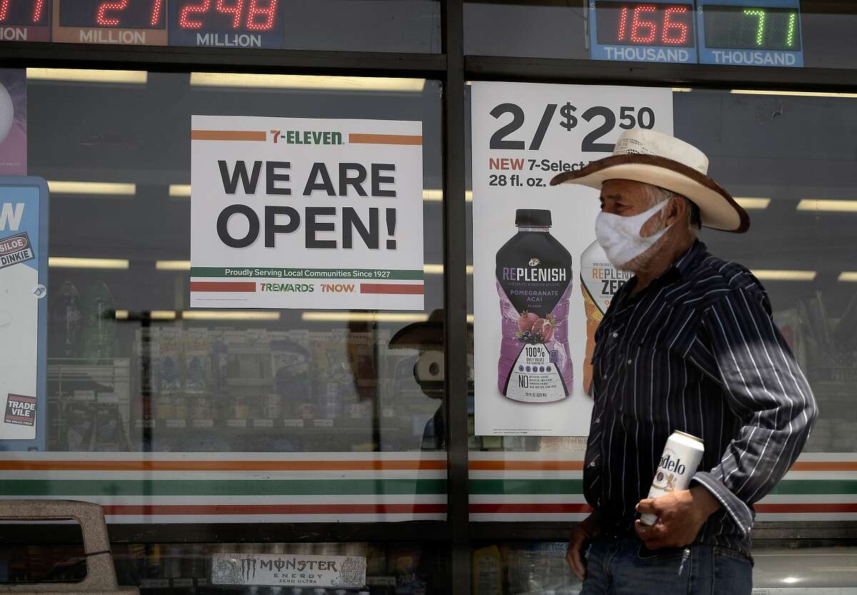 A man wearing a protective mask from the coronavirus leaves a 7-Eleven store Los Angeles on May 10. Although most Californians expect hard times ahead as the pandemic intensifies, a majority support Gov. Gavin Newsom’s handling of jobs and the economy, a new poll finds.