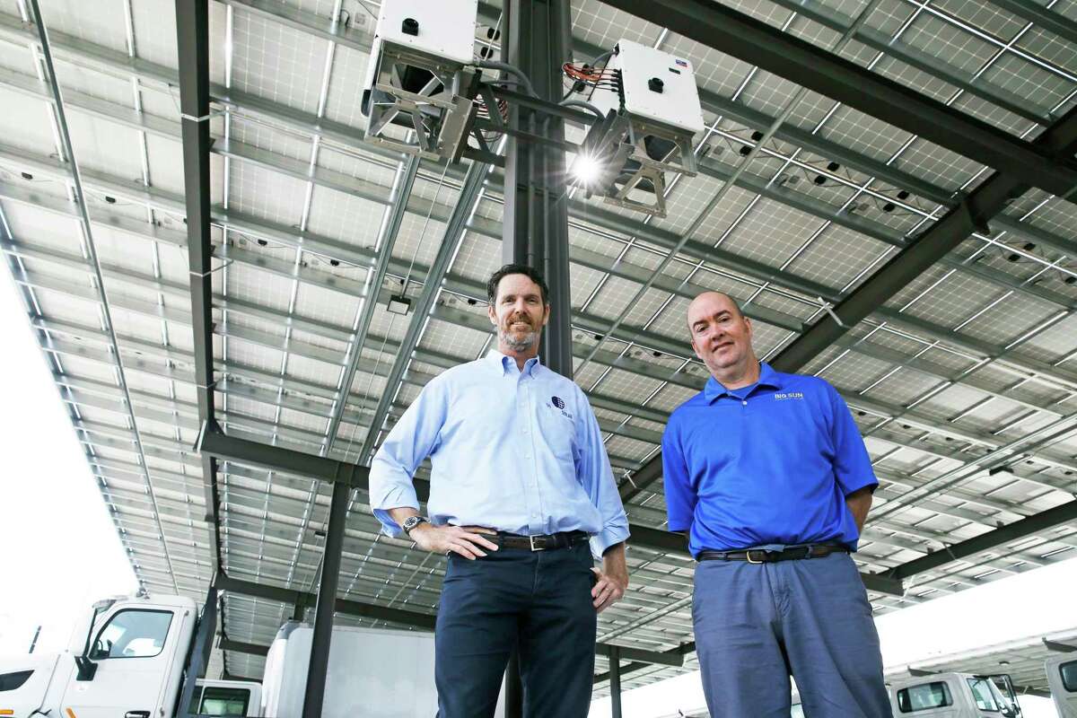 Big Sun Solar owners Robert Miggins, left, and Jason Pittman show off the solar panel arrangement last Wednesday that was installed at Rush Enterprises Truck Facility.