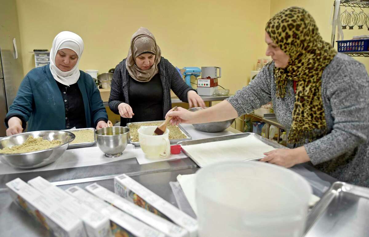New Haven, Connecticut - Wednesday, February 6, 2019: Faten Natfai of Syria, Hala Ghali of Syria, and Nieda Abbas of Iraq, left to right, making baklava at Katalina's bakery on Whitney Ave. in New Haven for Yale "butteries", late night cafe's at Yale are refugee chefs sponsored by Integrated Refugee and Immigrant Services.