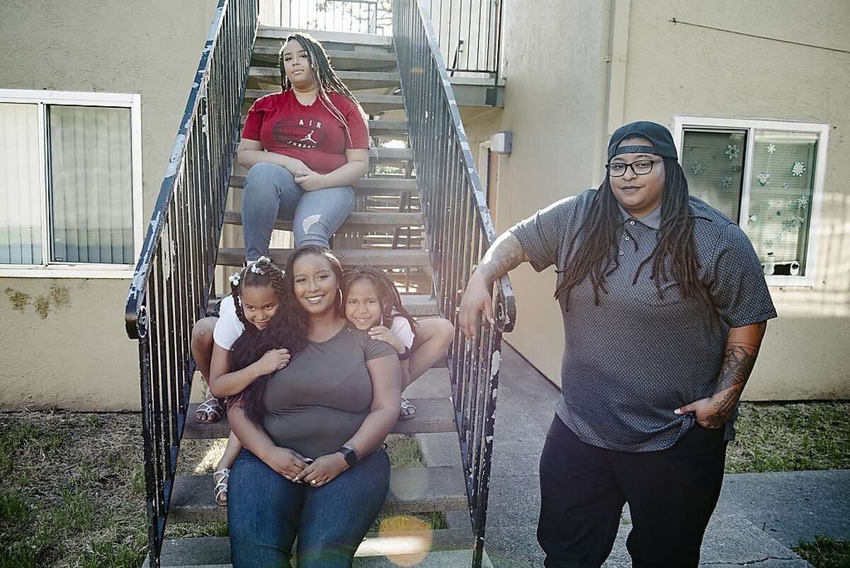Raven Winchester, right, poses for a portrait with her wife Symphony Luna, and daughters Malien Lindsy, Kataleya Lindsy and Anjalena Lindsy, outside their home in Oakland, Calif, on Friday, May 1, 2020. After years of custodial work, Winchester enrolled for Flockjay.com's tech sales courses, and is now a sales rep at the very company where she used to scrub toilets.