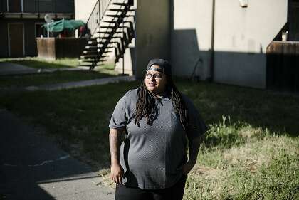 Raven Winchester stands for a portrait outside her home in Oakland, Calif, on Friday, May 1, 2020. After years of custodial work, Winchester enrolled for Flockjay.com's tech sales courses, and is now a sales rep at the very company where she used to scrub toilets.