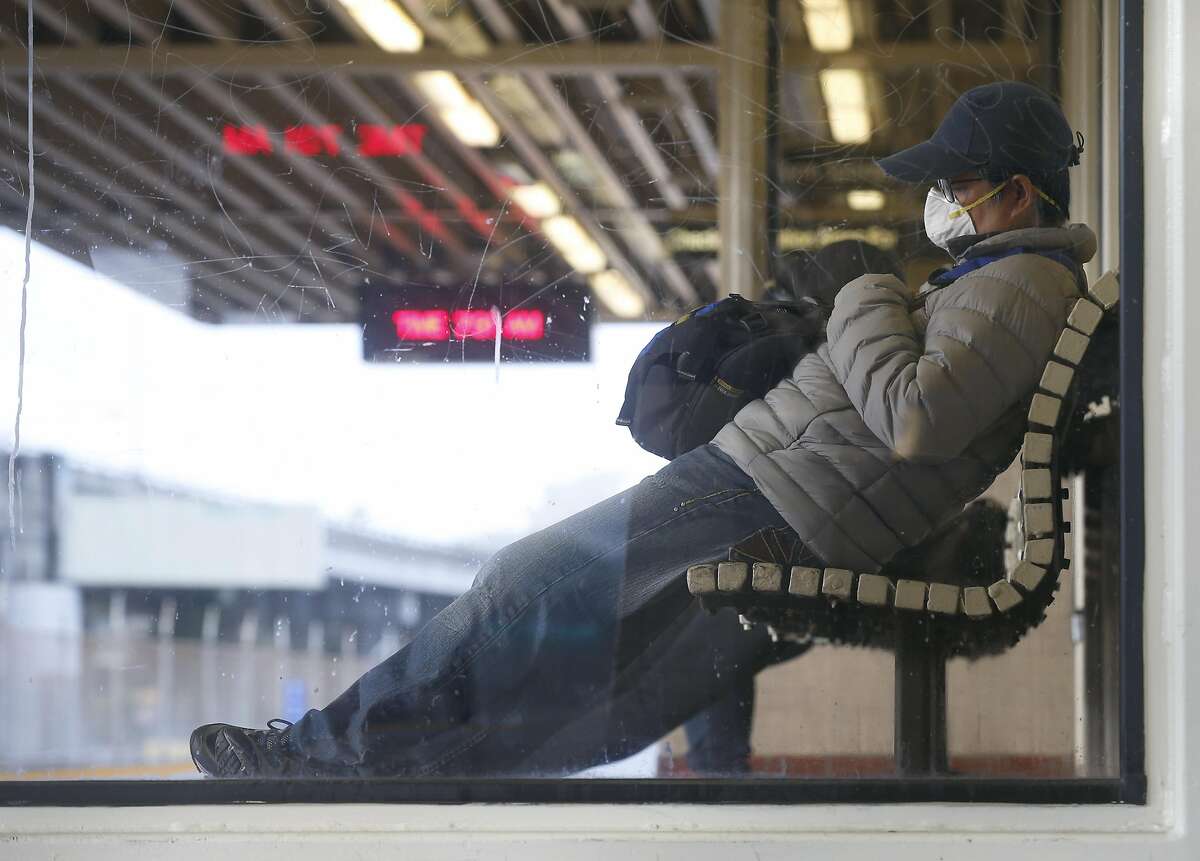 A commuter waits for a train to arrive at the MacArthur BART station in Oakland, Calif. on Tuesday, May 12, 2020. BART is joining transit agencies from around the country in seeking economic federal relief funds because of dwindling ridership during the coronavirus shutdown.