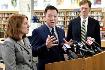 Connecticut Attorney General William Tong, center, New Haven Mayor Justin Elicker, right, and Connecticut Consumer Protection Commissioner Michelle Seagull, left, speak at Hillhouse High School in New Haven, Conn. Tong and Seagull announced March 24, 2021 that Connecticut would receive about $1.8 million through a 47-state settlement with medical-device manufacturer Boston Scientific.