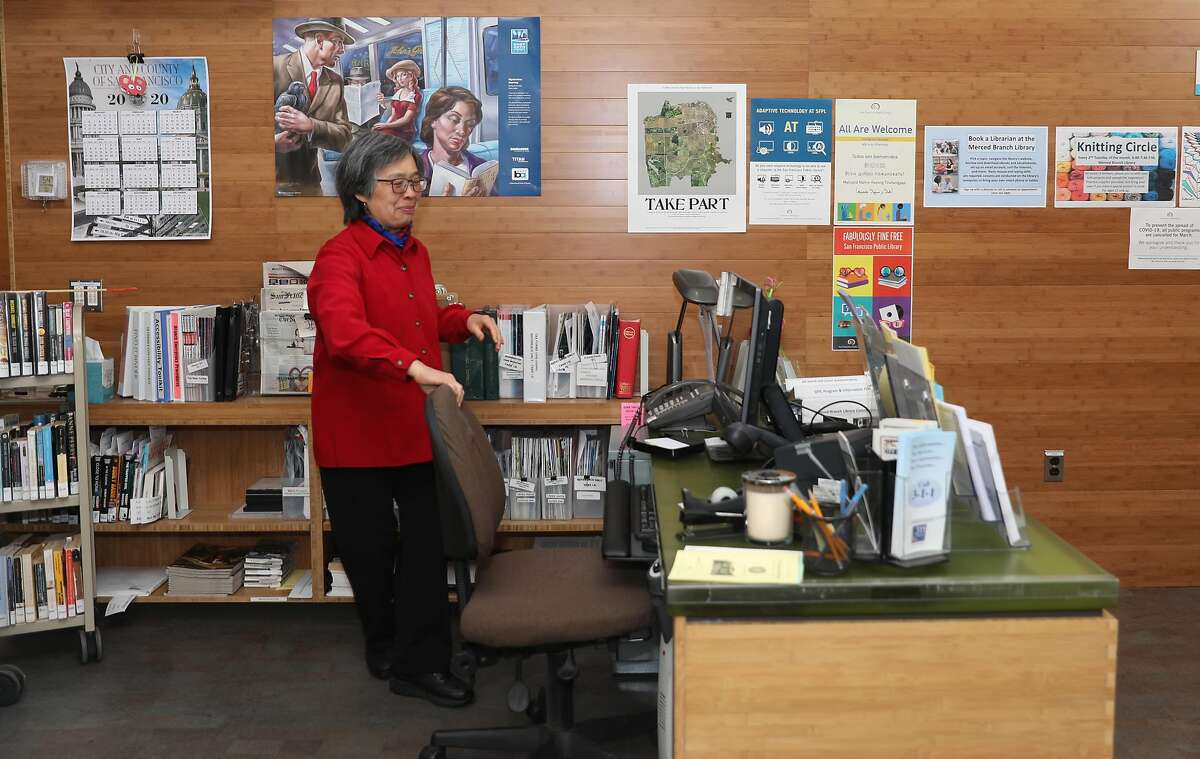 Jensa Woo has been a librarian for the past 40 years and tidies her desk at the SF Public Library Merced Branch which is presently closed as she visits it on Tuesday, May 12, 2020, in San Francisco, Calif. UCSF is helping California dramatically scale up its coronavirus contract tracing efforts with a new workforce training program that will recruit up to 20,000 individuals including Jensa Woo.