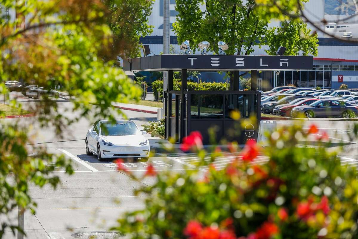A car waits at a stop sign as it prepares to exit the Tesla car factory on Monday, May 11, 2020 in Fremont, California. Tesla has reopened its Fremont car factory in defiance of county rules prohibiting car manufacturing during shelter-in-place.
