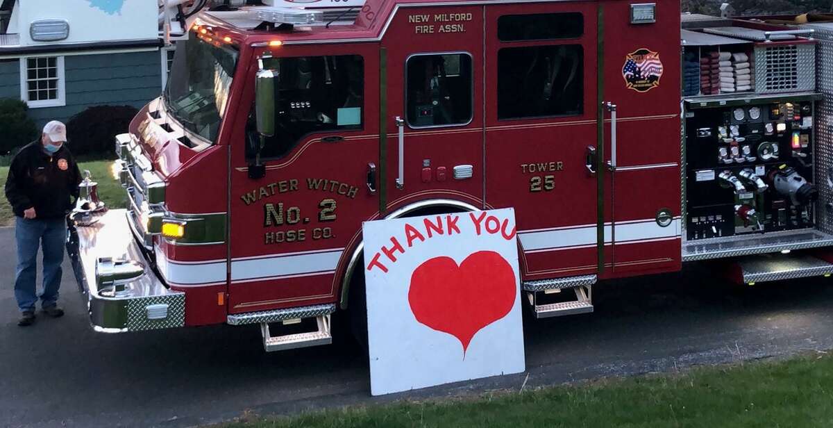 Dwayne Acton of Water Witch Hose Co. #2 in New Milford rings the bell on the fire truck May 12, honoring Spectrum Editor Deborah Rose, as a hero.