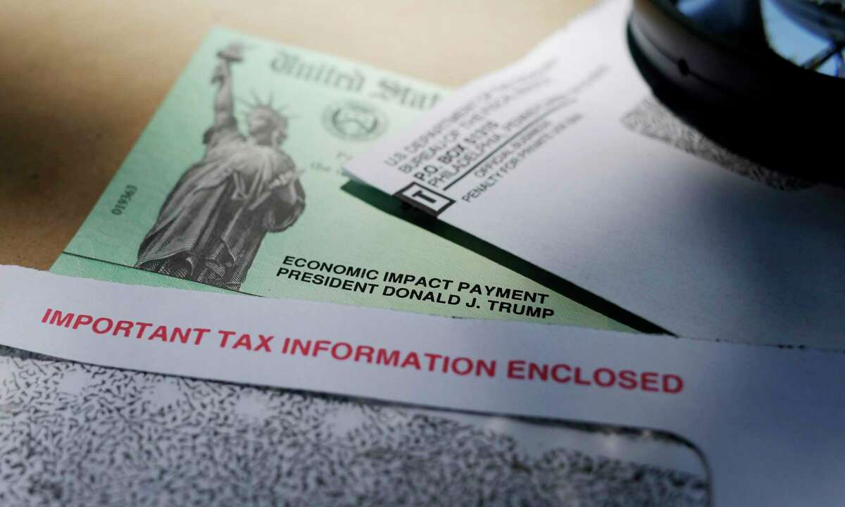 In this April 23, 2020, file photo, President Donald Trump's name is seen on a stimulus check issued by the IRS to help combat the adverse economic effects of the COVID-19 outbreak, in San Antonio. President Donald Trump, Treasury Secretary Steven Mnuchin and now the IRS are urging people who received coronavirus relief payments for a deceased taxpayer to return the money to the government. But legal experts say there is no law requiring people do that. (AP Photo/Eric Gay, File)