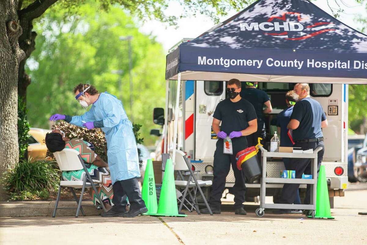 Paramedics with the Montgomery County Hospital District administer tests for COVID-19 outside of an elderly care facility, Thursday, May 14, 2020, at Focused Care at Beechnut in Houston.