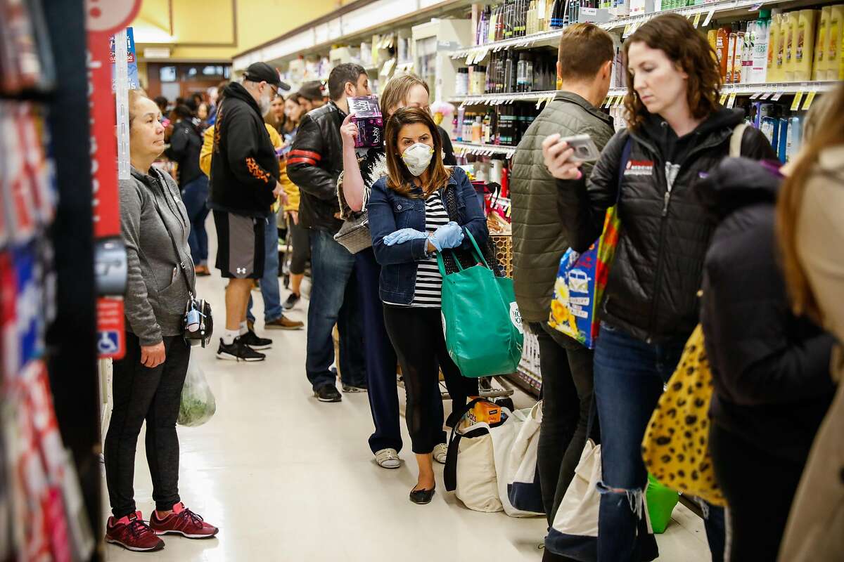 Dozens of people wait in line at Safeway after Mayor London Breed announced that six Bay Area counties would lockdown non-essential services due to the coronavirus on Monday, March 16, 2020 in San Francisco, California.