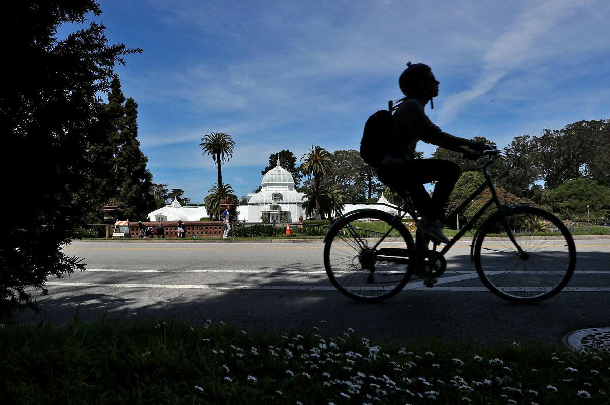 4月27日(星期一)，一名骑自行车的人在加州旧金山金门公园的肯尼迪大道上骑行。城市卫生官员将居家令延长至5月底，并将关闭街道，禁止车辆通行。