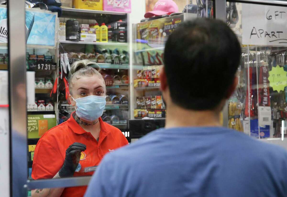 Cheyenne Kirkland wears a mask and gloves as she helps a customer at the Shell gas station on Medical Drive. Store manager Laura Salazar Adams has a set up a system where customers with weak immune systems — such as those undergoing chemotherapy, dialysis or other treatment — can call the station ahead of time. Employees will fill up their vehicle and ring up groceries so the customers don’t have to leave their cars. They even use Lysol before returning customers’ credit cards and cash.