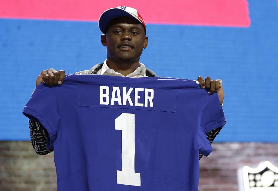 FILE - In this April 25, 2019, file photo, Georgia defensive back DeAndre Baker poses with his new jersey after the New York Giants selected him in the first round at the NFL football draft in Nashville, Tenn. Police in South Florida are trying to find Giants cornerback Baker and Seattle Seahawks cornerback Quinton Dunbar after multiple witnesses accused them of an armed robbery at a party. Miramar police issued arrest warrants for both men Thursday, May 14, 2020. (AP Photo/Mark Humphrey, File) Photo: Mark Humphrey / Associated Press