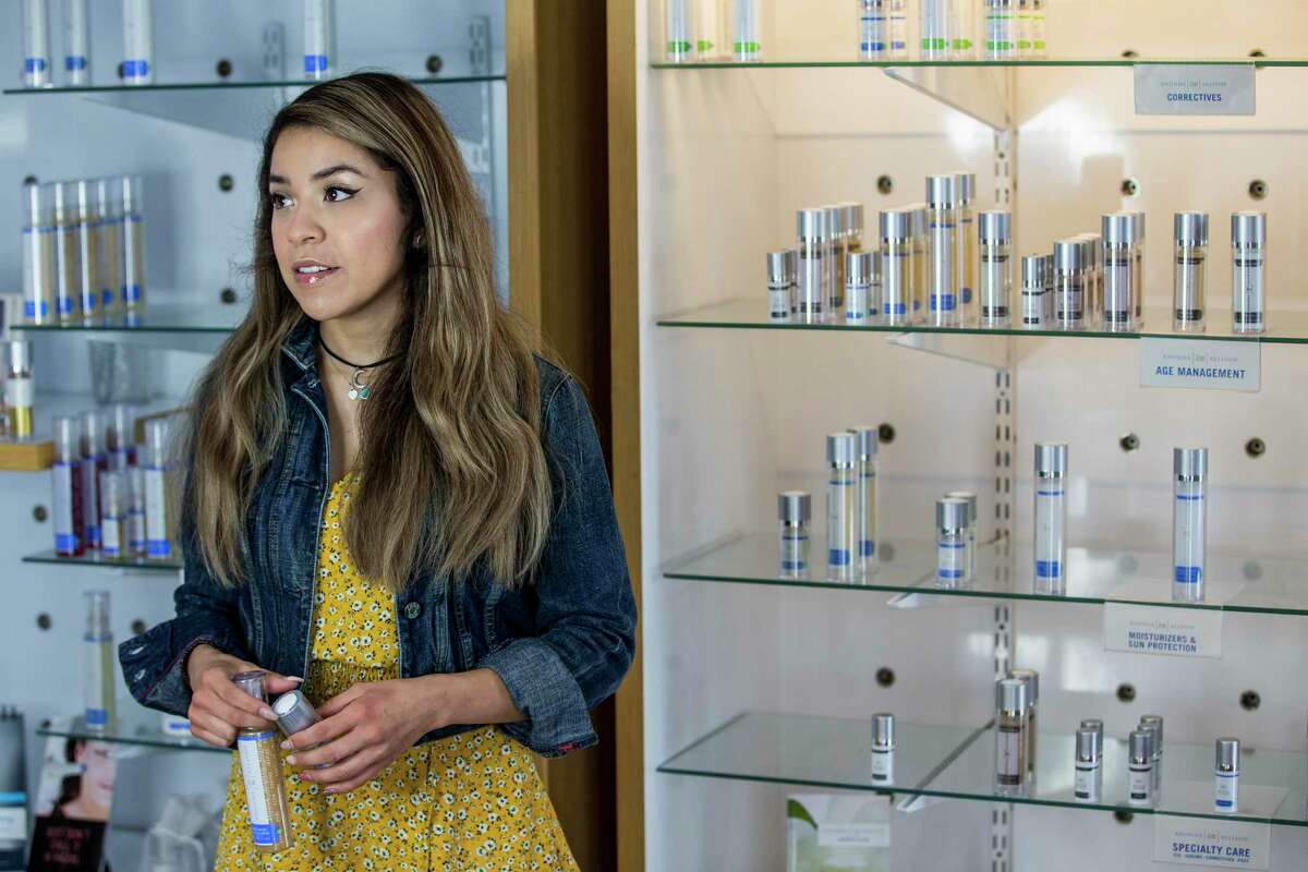 Ana Cervantes grabs products off a shelf at Light & Tight Medspa, while waiting for customers to pick up call in orders, on Saturday, April 11, 2020 in Richmond. The owner, Anna Elmore, who had to use her credit card to pay business expenses as she waited for Payceck Protection loan from the federal government.