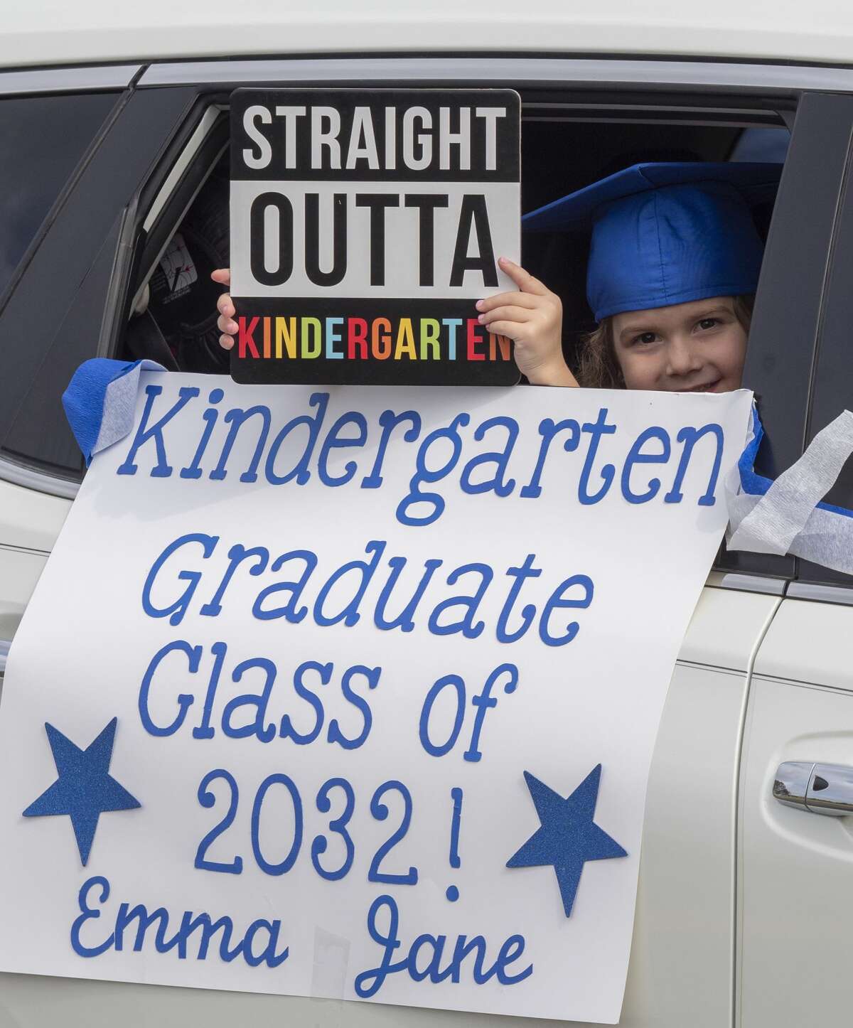 Emma Jane Wolf holds her sign out the window during graduation ceremonies 05/15/2020 as students and parents make their way along Trinity School parking lot for kindergarten graduation ceremony. Tim Fischer/Reporter-Telegram