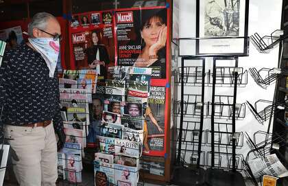 Fadi Berbery stands next to racks of some of the publications he sells at Smoke Signals on Polk Street in S.F. Berbery was ordered to shutter his shop because it is considered nonessential during the pandemic.