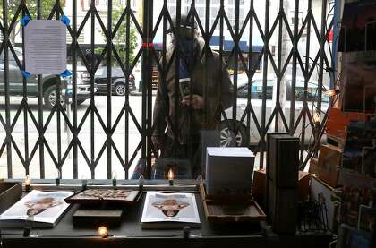 A passerby looks through the window at Smoke Signals.