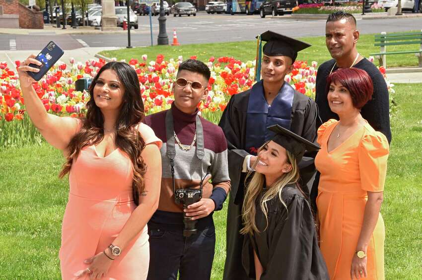 Back row from left, Shauneille Sinanan takes a selfie with Kyle Kissoon, University at Albany graduate Sherelle Sinanan, Clyde Sinanan, front row from left, University at Albany graduate Tunisha Haque, and Shanti Sinanan outside the Capitol on Friday, May 15, 2020 in Albany, N.Y. The family was taking photos of the grads in their caps and gowns by the tulips today since there isn't a traditional commencement ceremony. (Lori Van Buren/Times Union)