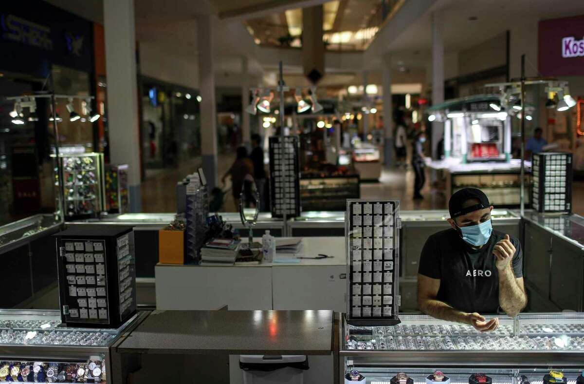 Mohammad Irfan waits for customers Friday, May 1, 2020, at PlazAmericas mall in Houston. while retailers were allowed to open in May following shutdown orders to slow the spread of the coronavirus, experts say that a drop in consumer spending due to mass layoffs, as well as a turn toward online shopping to minimize exposure to the virus, means many businesses will struggle this year.