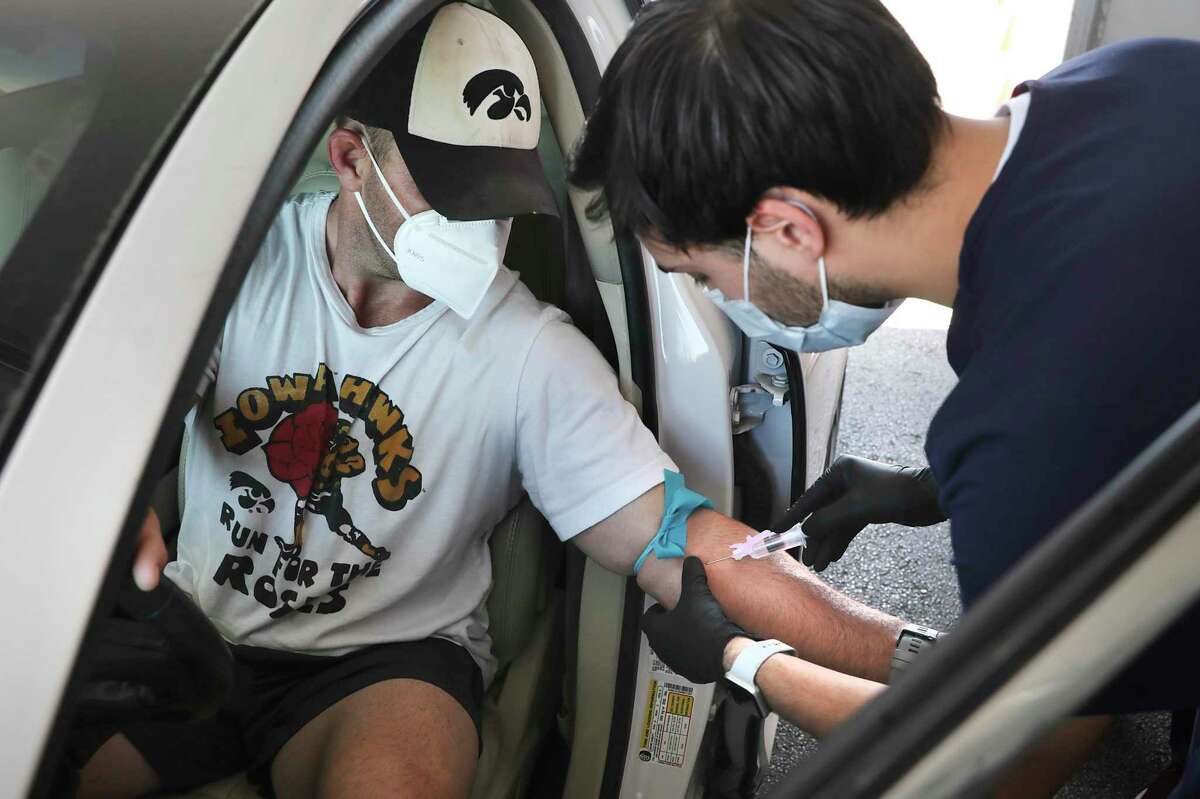 Jacob Gaier, a medical assistant with Remedy, an Austin-based telemedicine company that opened a drive-up site in San Antonio, takes a blood sample from Blake Anderson on Thursday, May 14, 2020, for an antibody test for the coronavirus.