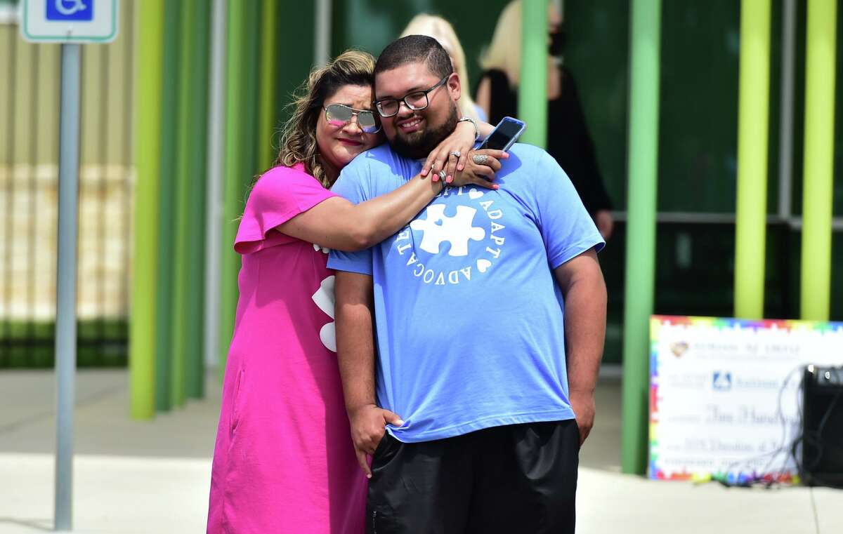 Adrian “A.J.” Ortiz gets a hug from his mother, Deseri Ybarra, during a celebration for the teen, whose handcrafted key chains raised money for the Autism Treatment Center.