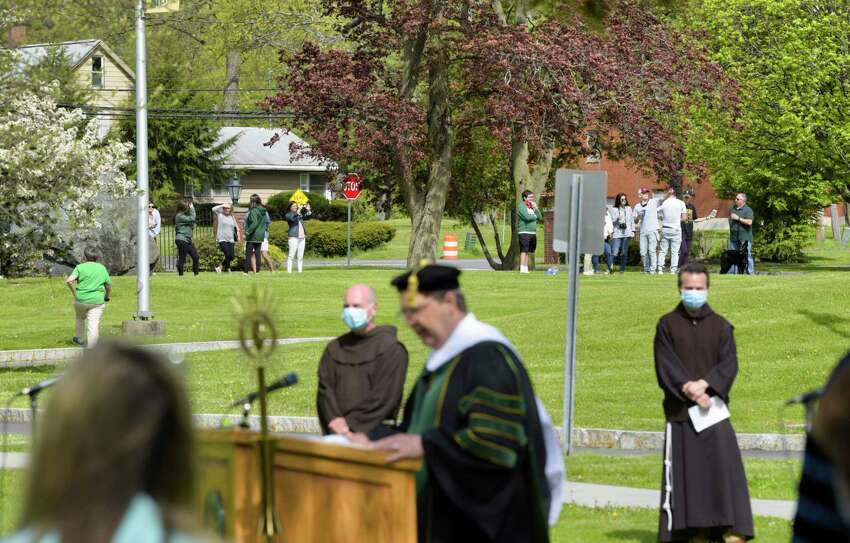 Some Siena College graduates and their families gather on the lawn of the college as Charles Seifert, interim vice president for academic affairs, foreground, speaks at a ceremony to honor the Class of 2020 at Siena College on Sunday, May 17, 2020, in Loudonville, N.Y. The ceremony was streamed live on Siena's Facebook page. College officials announced that they are tentatively planning for an actual graduation ceremony for the class of 2020 on August 15th. (Paul Buckowski/Times Union)