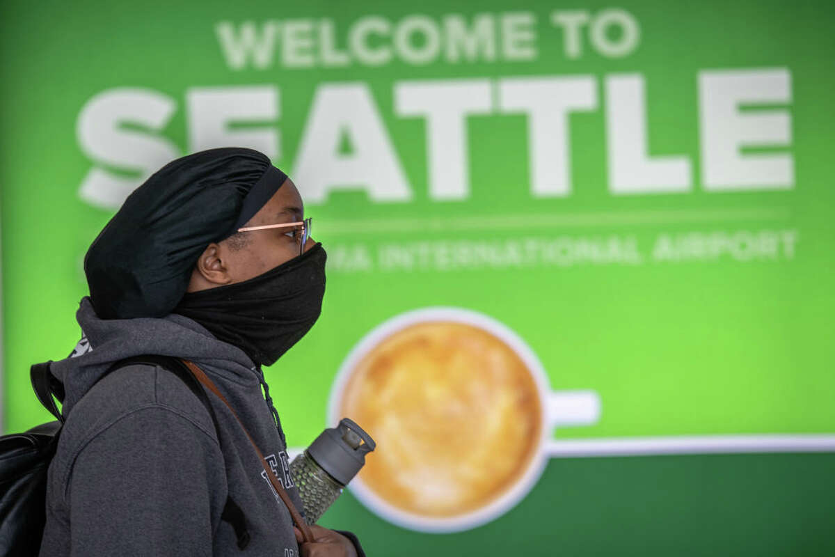 SEATTLE, WA - MARCH 15: A passenger wearing a mask walks through the Seattle-Tacoma International Airport on March 15, 2020 in Seattle, Washington. The state of Washington has over 600 confirmed cases of coronavirus (COVID-19) and U.S. airports have been crushed with returning citizens after restrictions on travel from Europe were implemented. (Photo by John Moore/Getty Images)