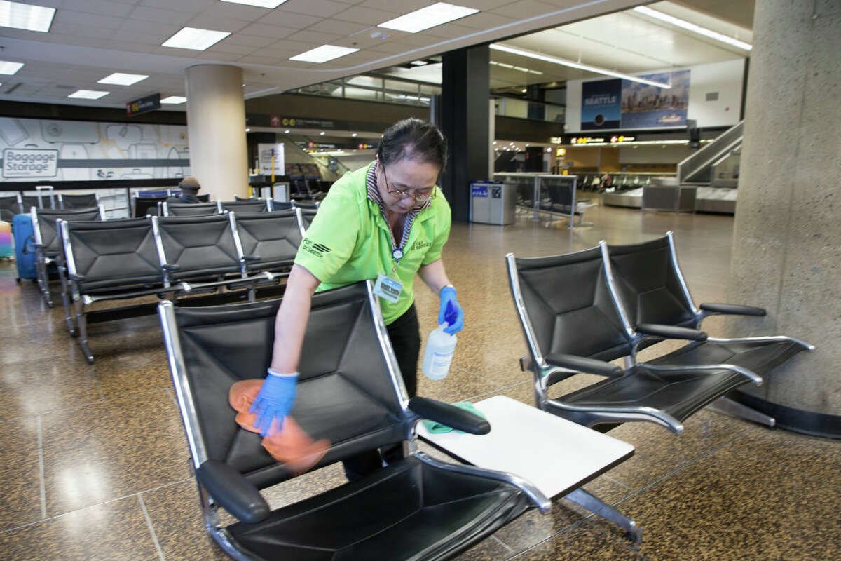 SEATTLE, WA - MARCH 08: Vui Truong, from Burien, WA cleans a seating area Seattle-Tacoma International Airport (also known as Sea-Tac Airport) on March 8, 2020 in Seattle, Washington. The airport has increased cleaning frequencies at all high touch point areas in response to the outbreak of the novel coronavirus, COVID-19. (Photo by Karen Ducey/Getty Images)