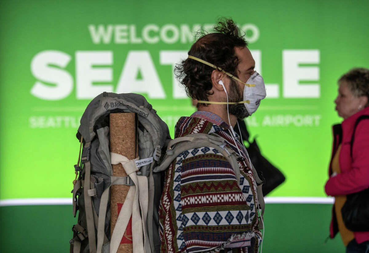 SEATTLE, WA - MARCH 15: A passenger wearing a mask prepares to board a flight departing the Seattle-Tacoma International Airport on March 15, 2020 in Seattle, Washington. The state of Washington has over 600 confirmed cases of coronavirus (COVID-19) and U.S. airports have been crushed with returning citizens after restrictions on travel from Europe were implemented. (Photo by John Moore/Getty Images)