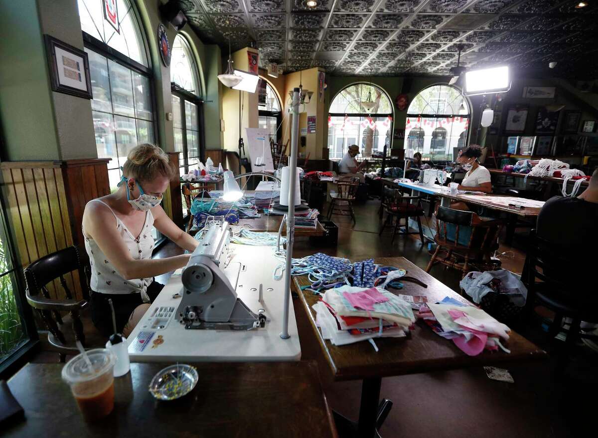 Courtney Wyckoff sews masks inside of the Maple Leaf Pub, in Houston, Thursday, May 7, 2020. Courtney and her husband Micahl started making masks out of their home after both finding themselves out of work because of coronavirus. Courtney, a seamstress, used leftover fabric she had lying around the house to start making the mask. They also started hiring their other out of work friends to help them. Their business is Grab Bag Masks.com.