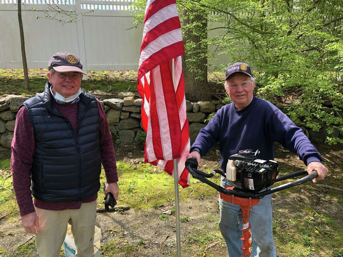 Jim Finklea and Mike Anderson help install an American flag in town.