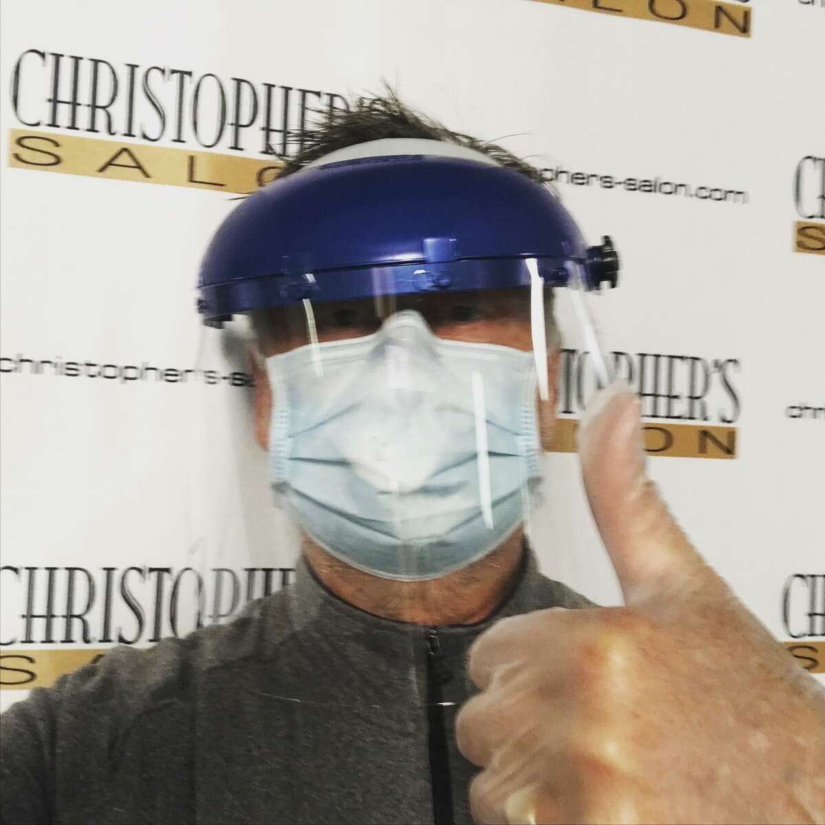 Christopher's Salon owner Christopher Rollins models the protective gear he planned to use in the salon on reopening Wednesday.