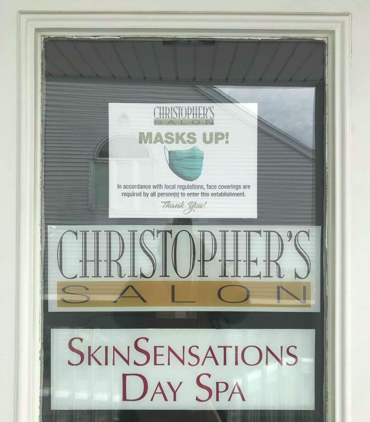 A sign at Christopher's Salon in Guilford reminds people to wear masks.