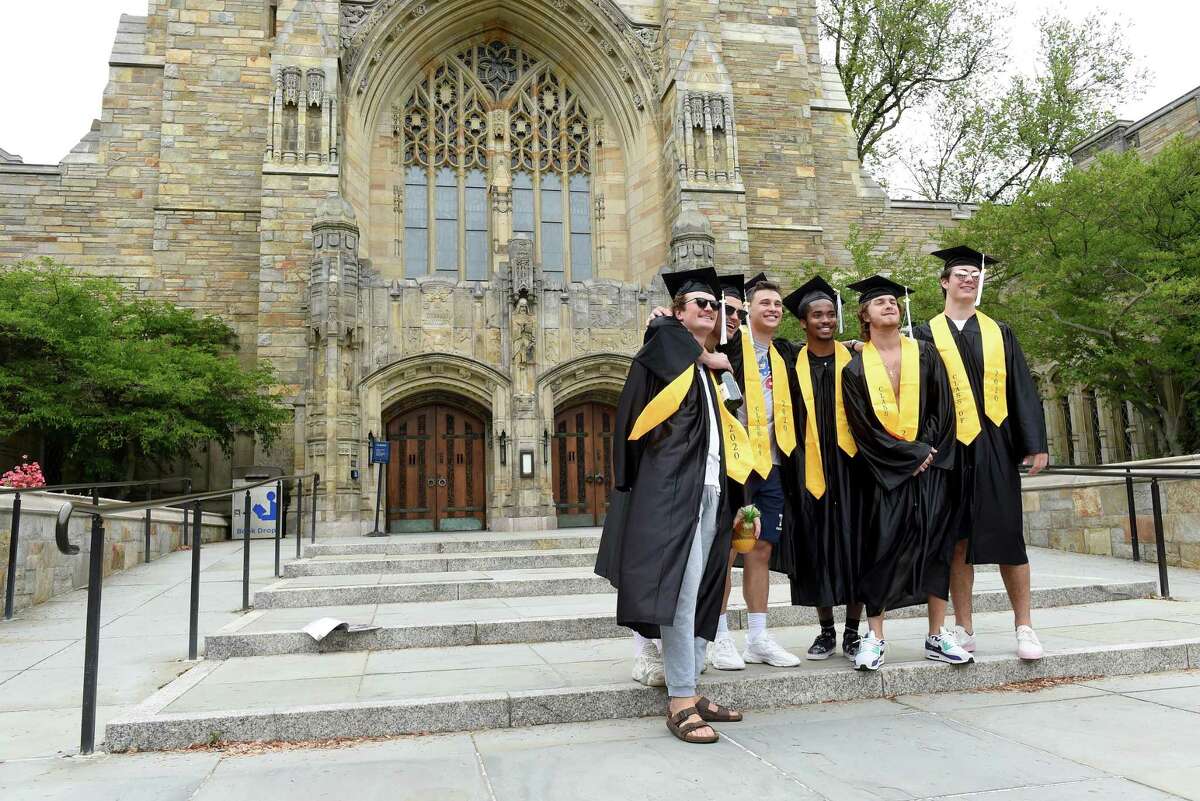 Yale University graduates pose for photographs on Cross Campus in New Haven on what would have been their commencement on May 18, 2020. Yale University President Peter Salovey delivered an address and conferred degrees via YouTube.