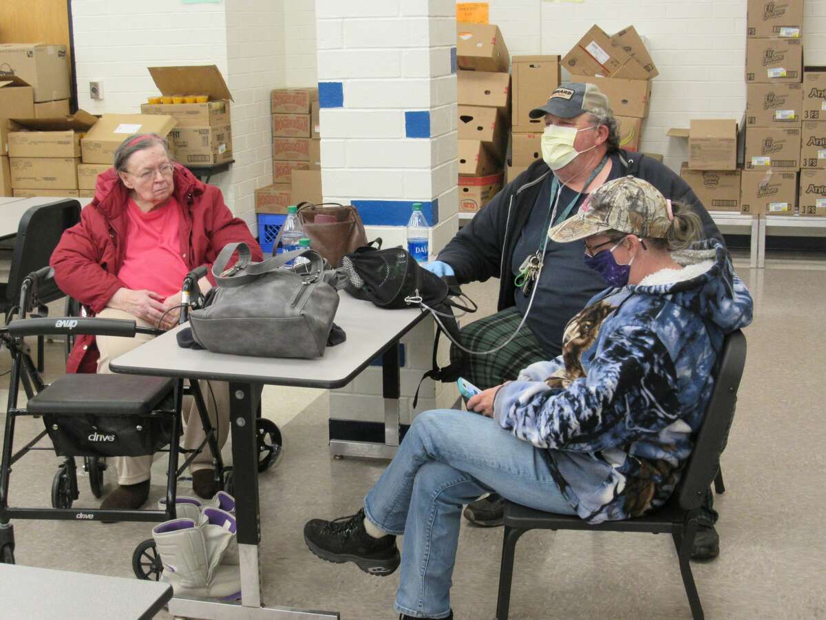 Left to right, Lorraine Petersen, Jon St. Croix and Sharon St. Croix sit in the shelter space set up in the cafeteria of Meridian Jr. High School after being evacuate from their homes on Wixom Lake on May 19, 2020.