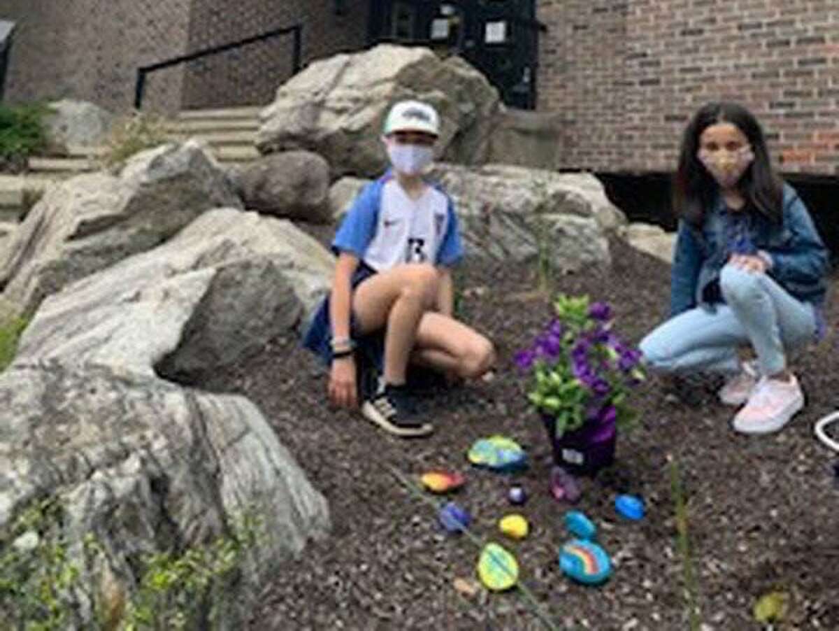 Two fourth graders from Cider Mill School placed hand-painted rocks with inspirational messages and flowers outside Wilton Police, Fire and WVAC headquarters.