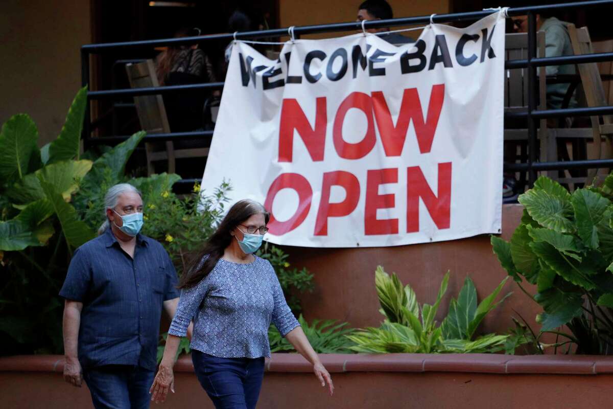 Visitors to the River Walk pass a restaurant that has reopened in San Antonio, Monday, May 18, 2020. Texas Gov. Greg Abbott announced Monday that bars and bowling alleys are on the list of business that can reopen at 25 percent beginning Friday and restaurants can increase to 50 percent capacity as the state continues to go through phases to reopen the state after closing many businesses to battle the spread of the coronavirus. (AP Photo/Eric Gay)