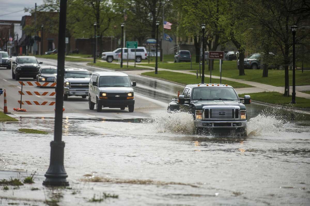 Vehicles drive through floodwater in downtown Gladwin Tuesday, May 19, 2020. (Katy Kildee/kkildee@mdn.net)