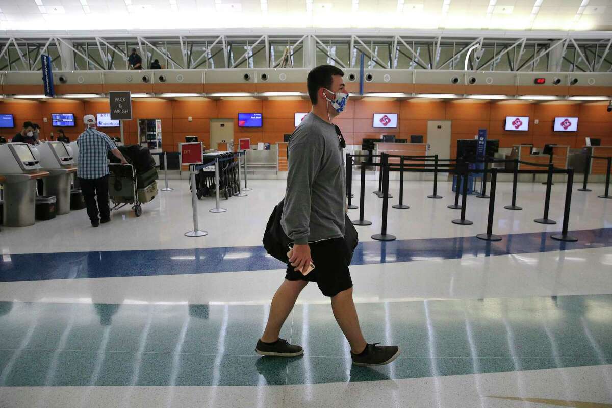 Reed Buce wears a mask as he walks to his flight's gate on Monday, May 18, 2020. Travelers at San Antonio International Airport are still a fraction of the numbers pre-COVID-19 but the few who are traveling by plane are often essential workers or coming to aid of loved ones. Data shows there has been a slight pickup of passengers as stay at home orders have been limited.