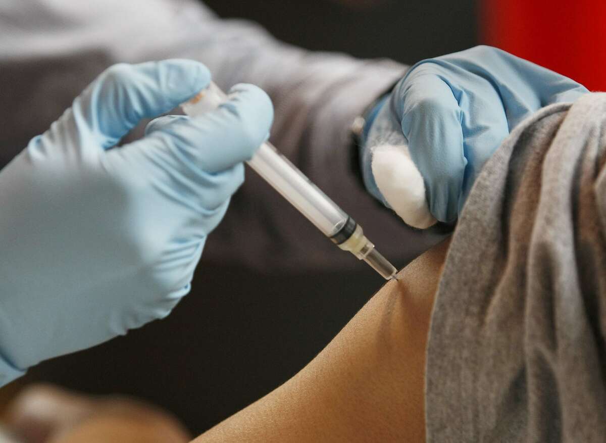 A volunteer gives a free Pertussis (whooping cough) vaccination to a young boy at Roosevelt Middle School in San Francisco Calif, on Saturday, March 19, 2011. Those receiving the shot can occasionally have an adverse reaction and at least one child fell unconscious after receiving the vaccine.