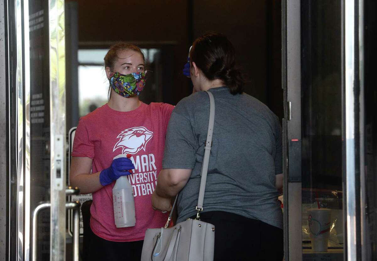 Kara Pent takes temperatures of people entering the Jefferson County Courthouse, including screener Riley LeLeux, Tuesday. Anyone entering the facility must be screened for any indication of favor in order to proceed. Photo taken Tuesday, May 19, 2020 Kim Brent/The Enterprise